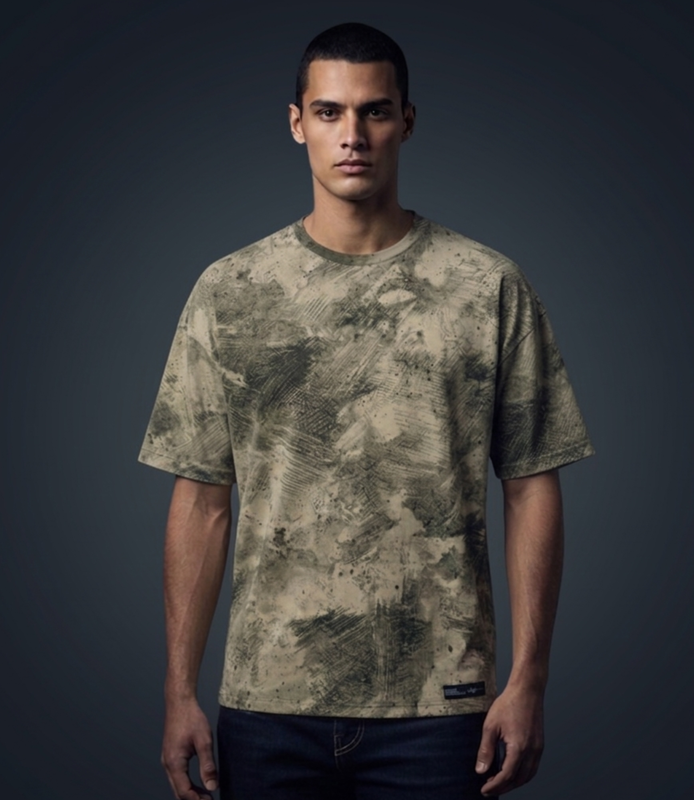 Man wearing a camouflage t-shirt against a dark background