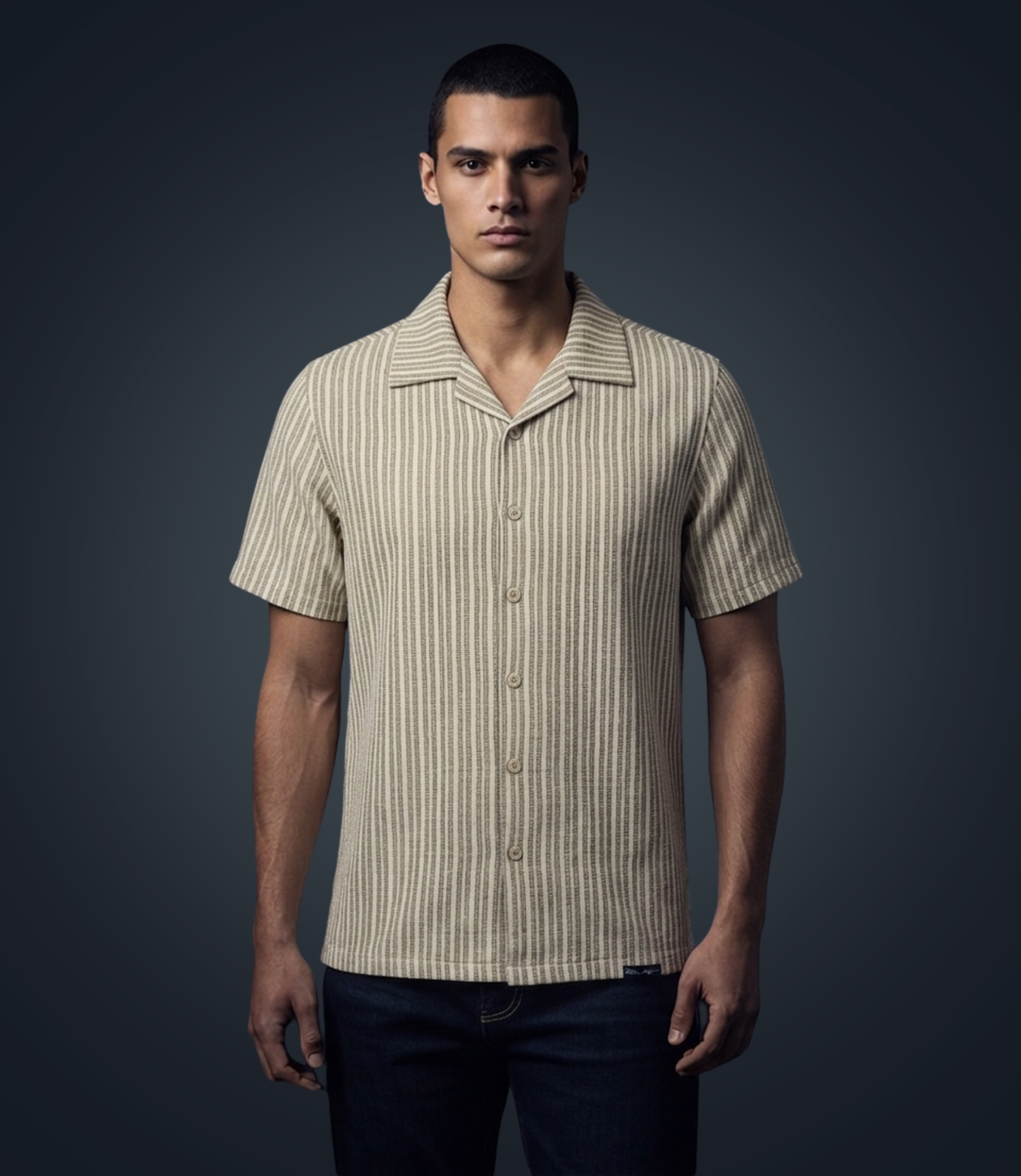 Man wearing a beige striped shirt against a dark background