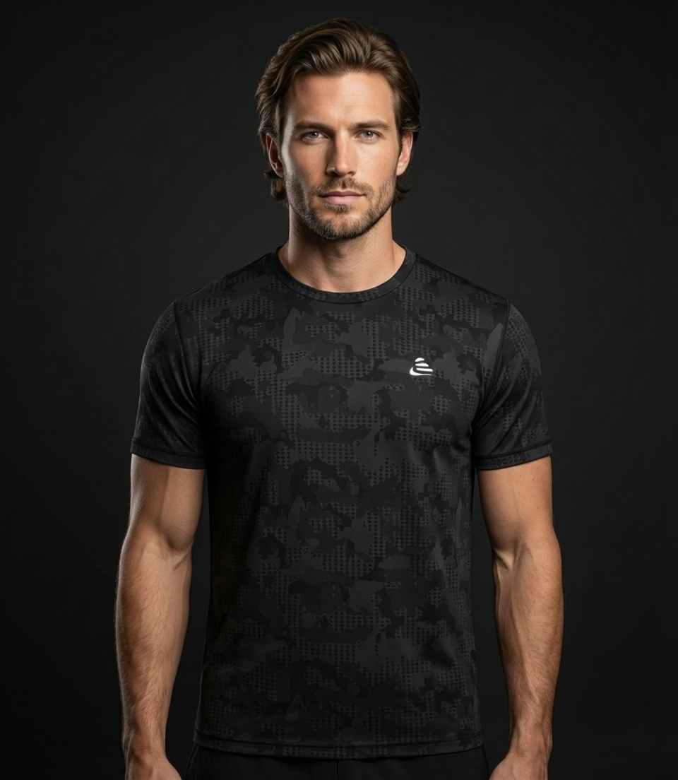 Man wearing a black athletic shirt with a logo on a dark background