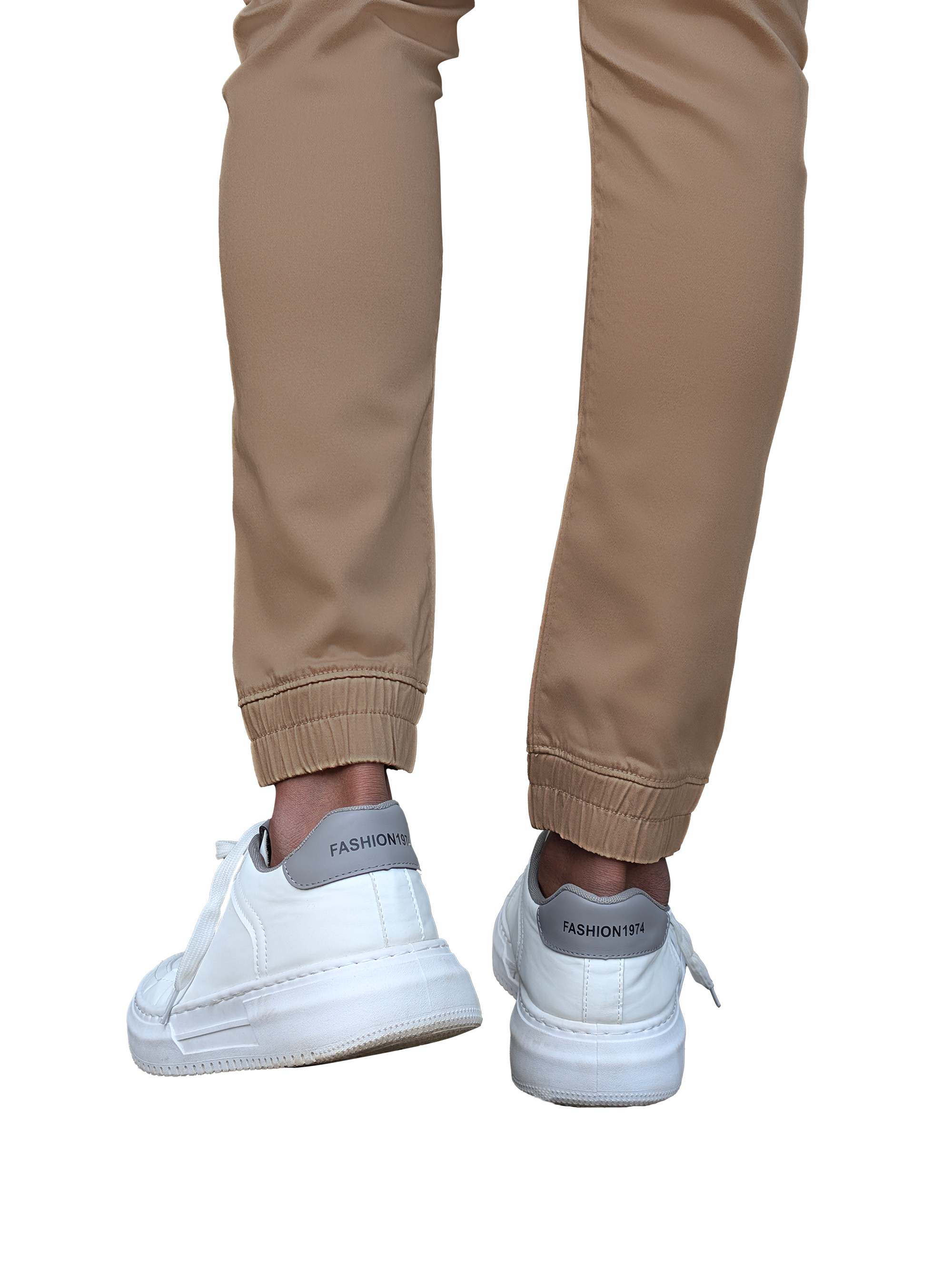 Beige pants worn with white sneakers on a white background
